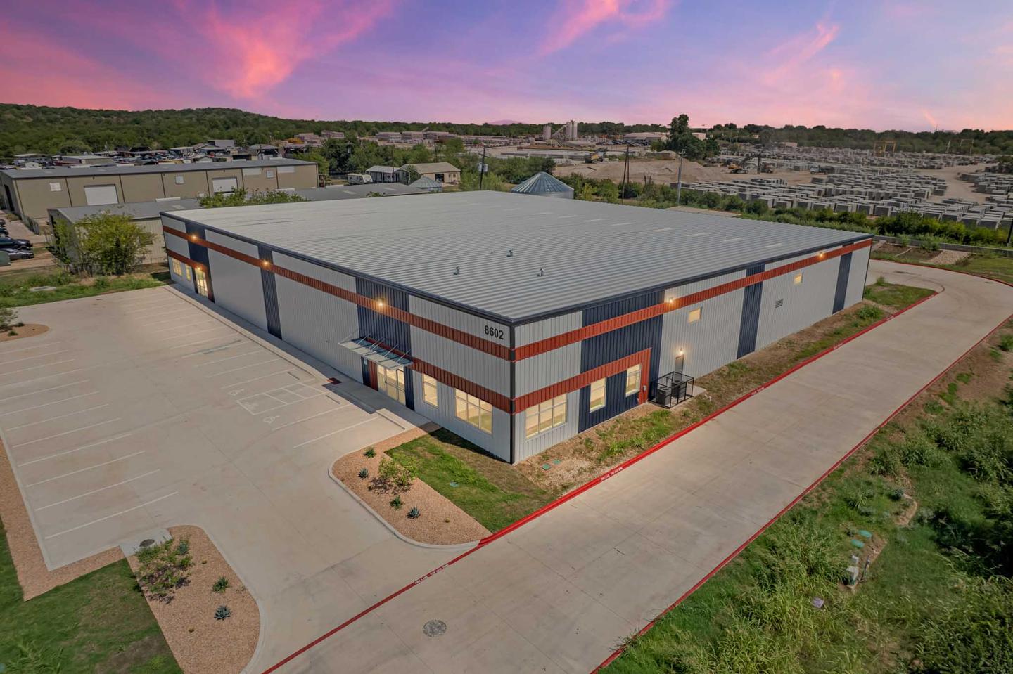 Aerial view of an East Austin flex building and its yard photographed at dusk