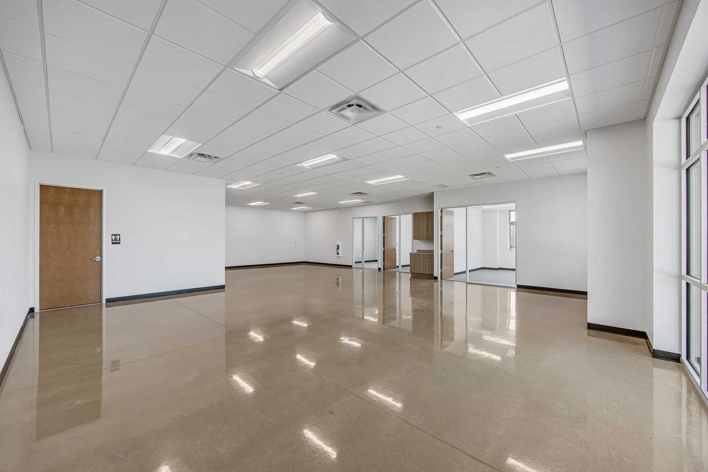 Empty office suite in Austin with polished floors and a run of ceiling lights