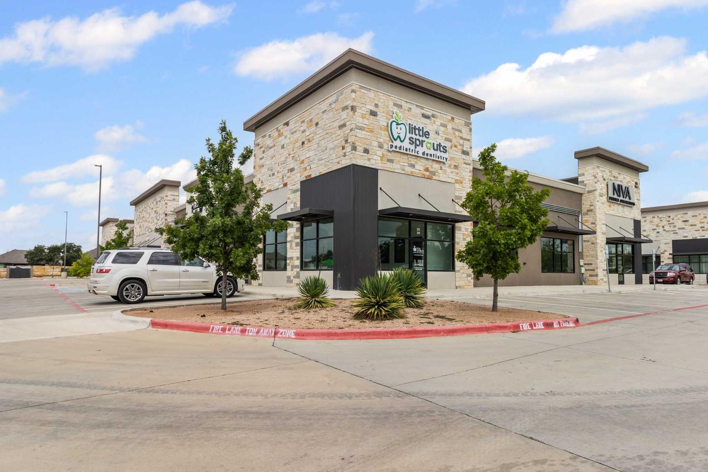 Single story retail building in West Austin with stone and dark cladding and a corner entrance