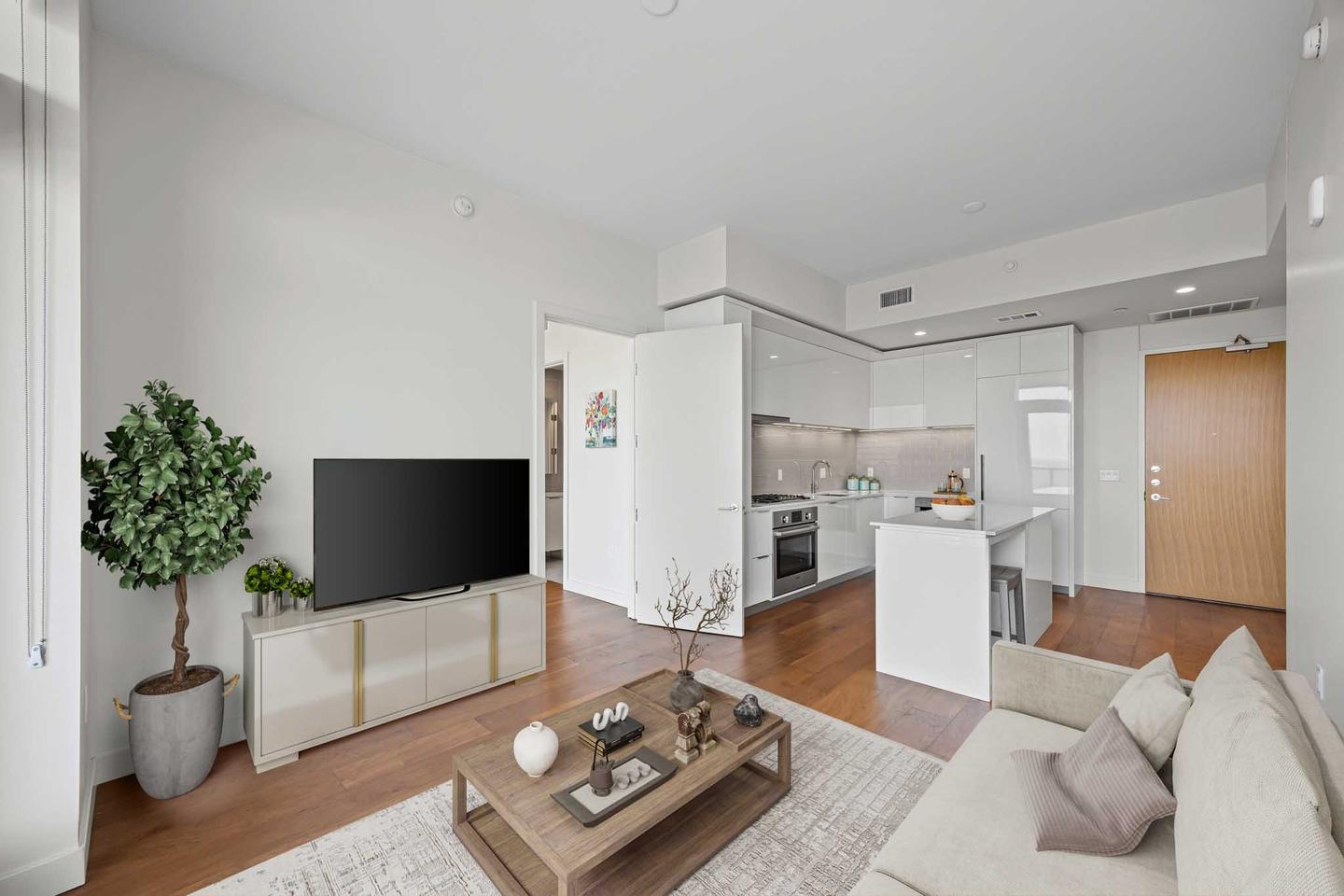 East Austin condo living area staged with a pale sofa, a television and a plant
