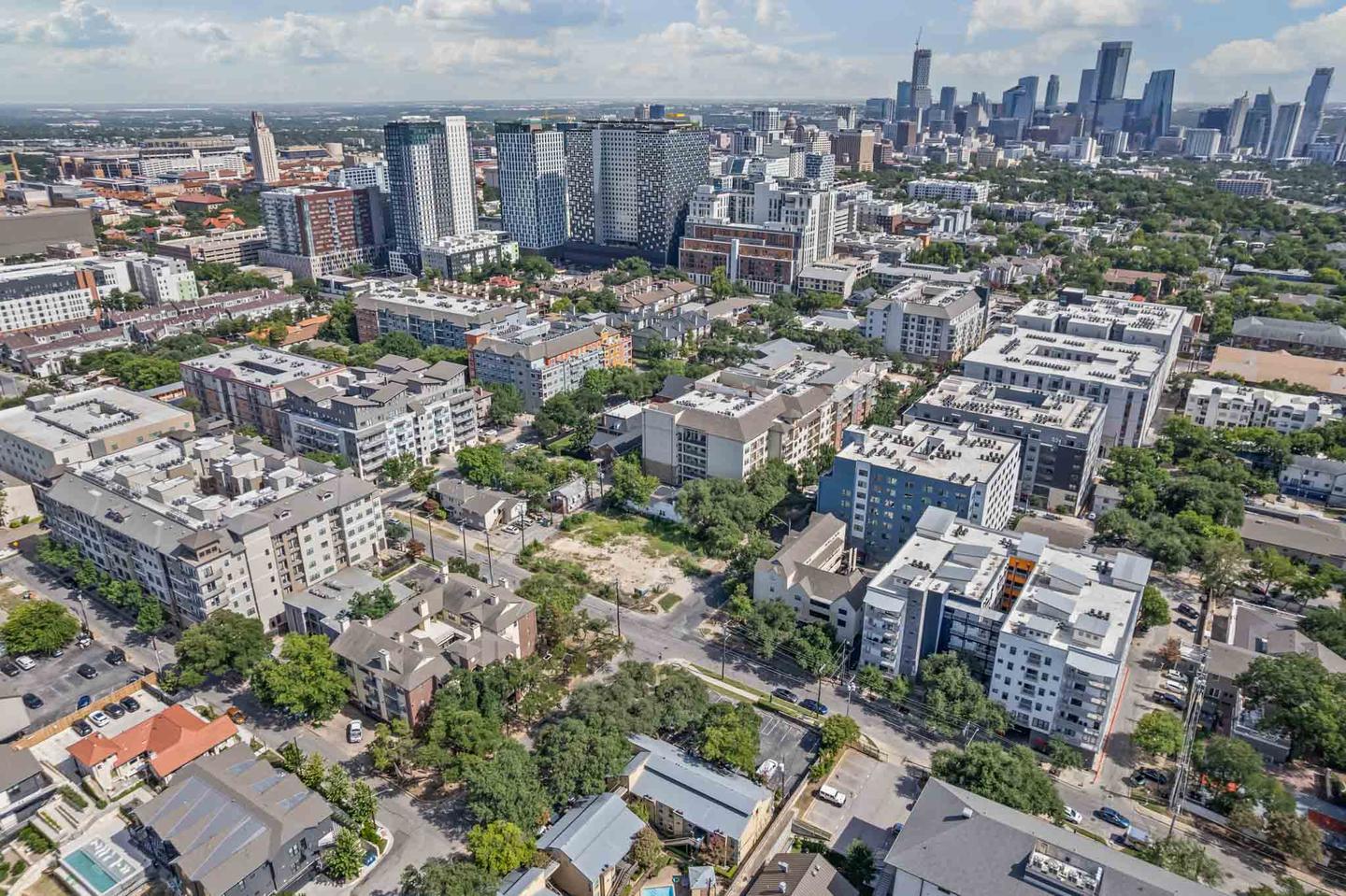 Aerial view of a downtown Austin apartment tower with the skyline behind it