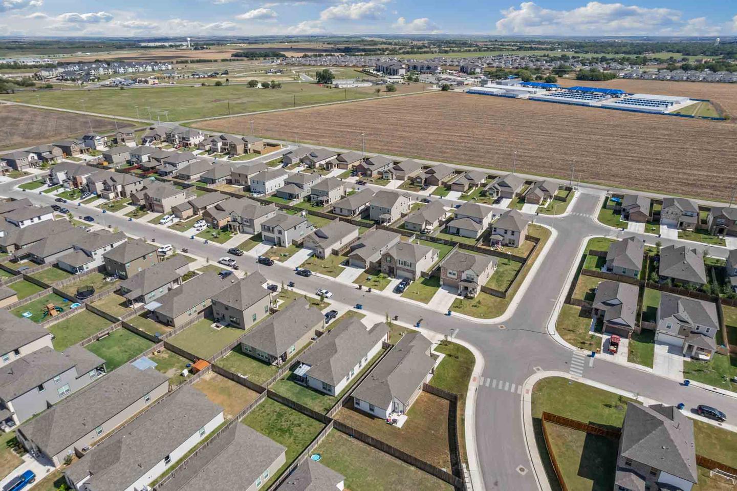 Aerial view of a Round Rock home and its street, showing the lot and the neighborhood around it