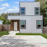 Two story residential home in Lockhart with a light gray exterior and a wood front door