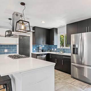 East Austin short term rental kitchen with a white quartz island and bar stools