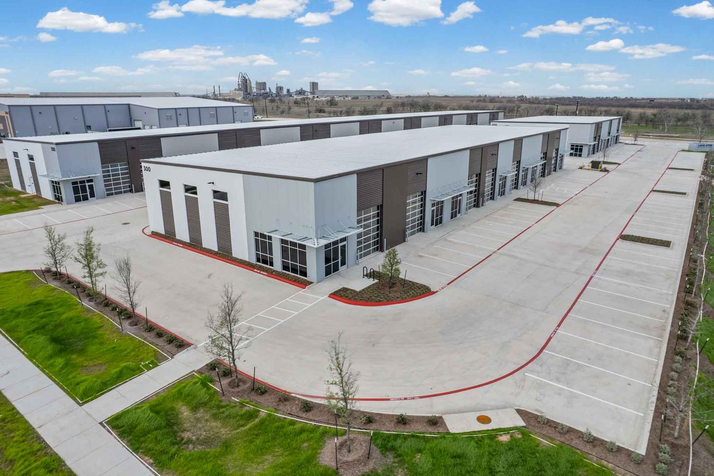 Aerial view of a completed row of new build commercial units in Buda with fresh paving and landscaping