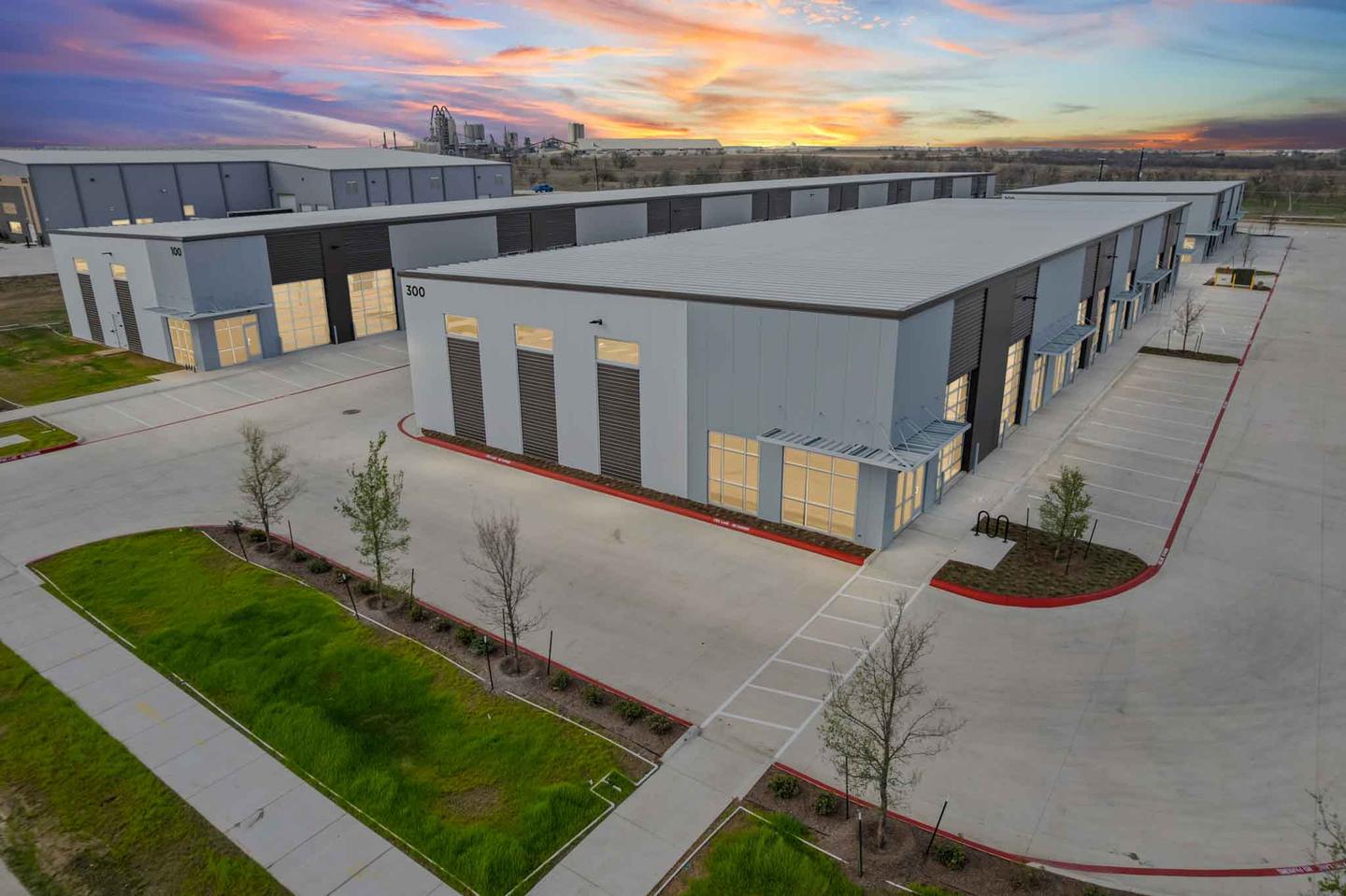 Aerial view of a completed development in Buda photographed at dusk under an orange sky