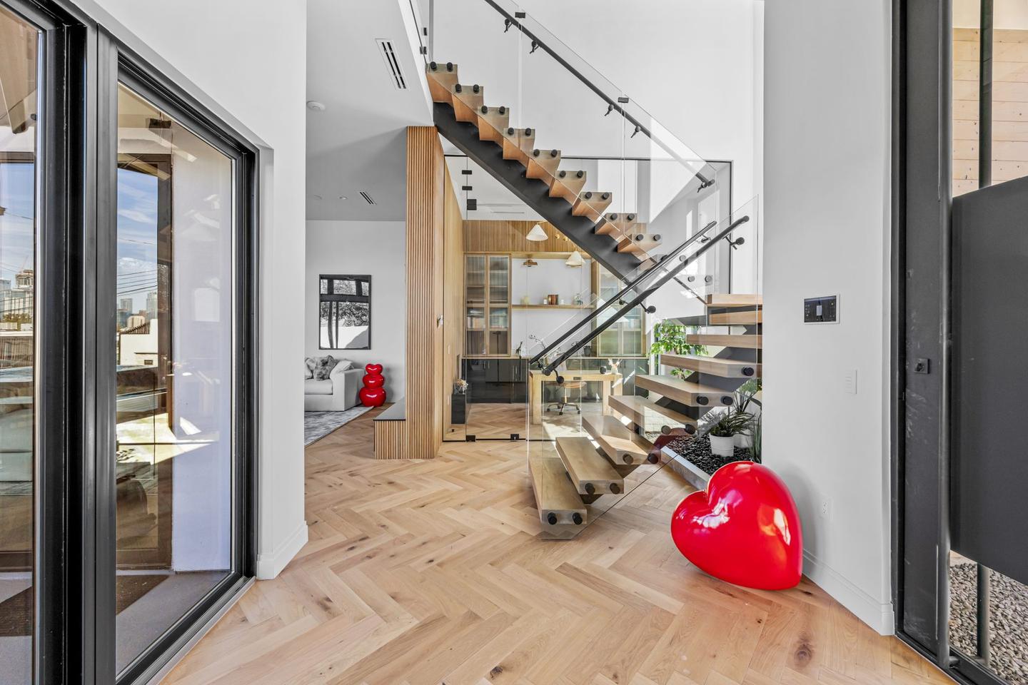 Glazed corner of a modern Austin home with a floating timber stair behind full height glass