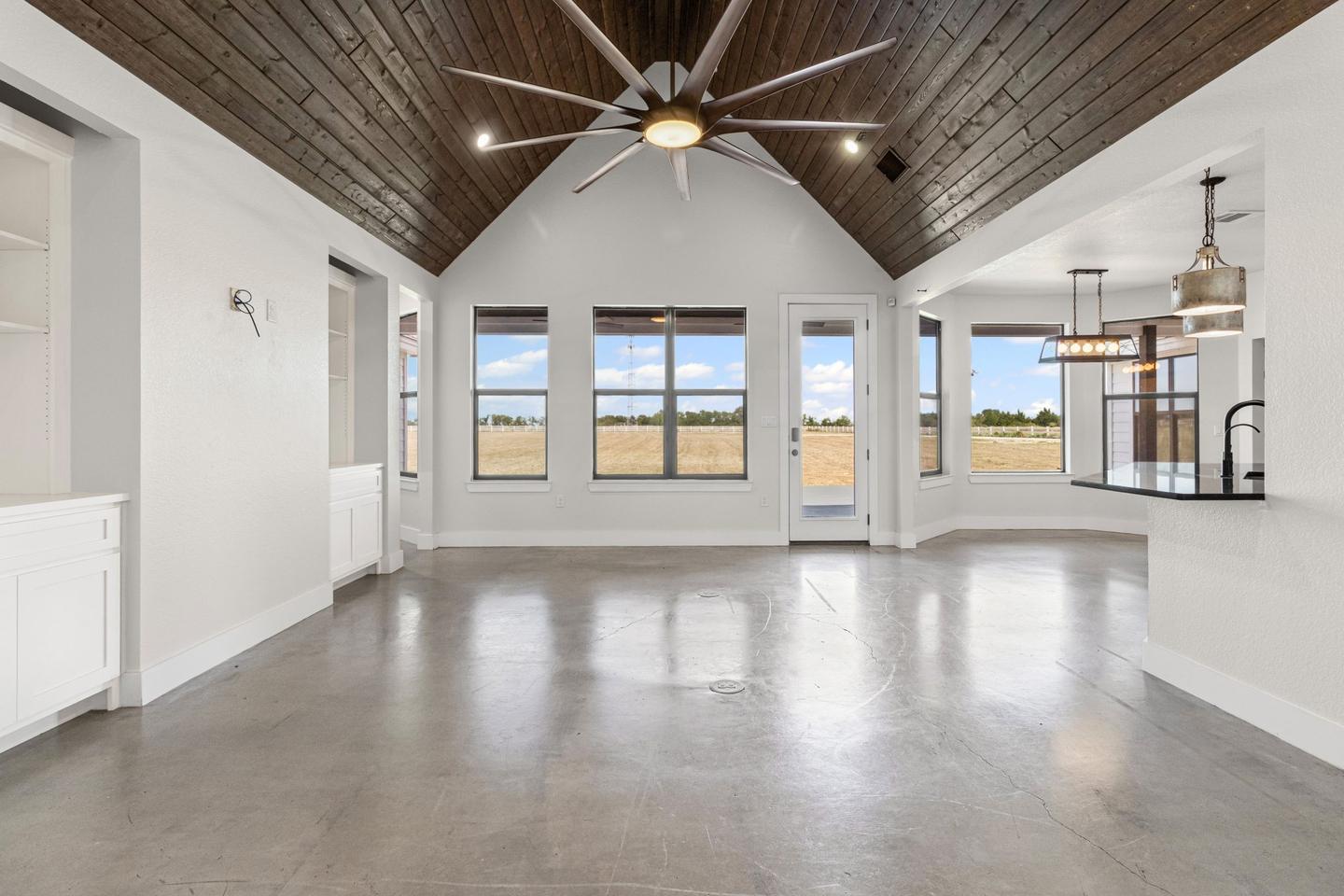 The same great room empty, showing the polished concrete floor and the timber vaulted ceiling