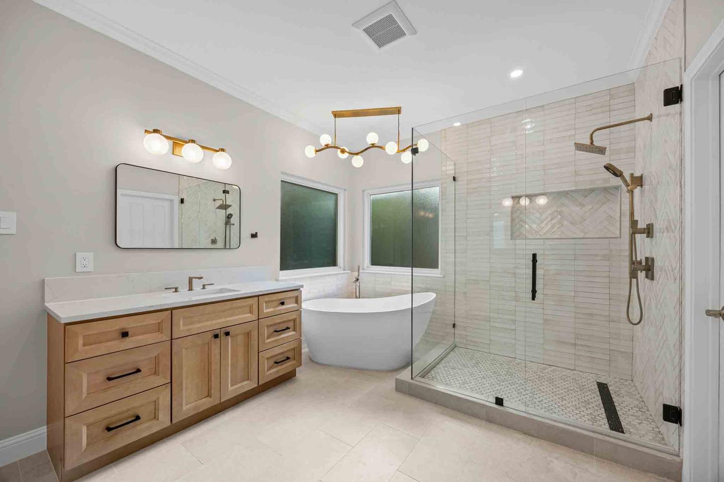 Renovated bathroom with a wood vanity, freestanding tub and a glass walk in shower