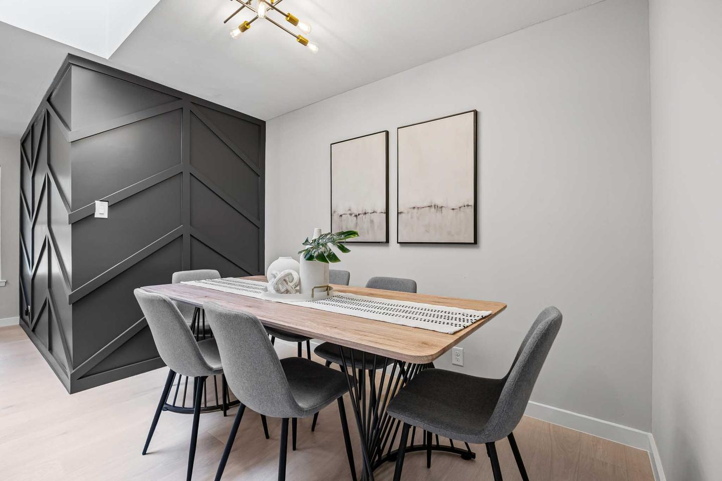 Dining room in Austin with a dark paneled accent wall and modern black chairs