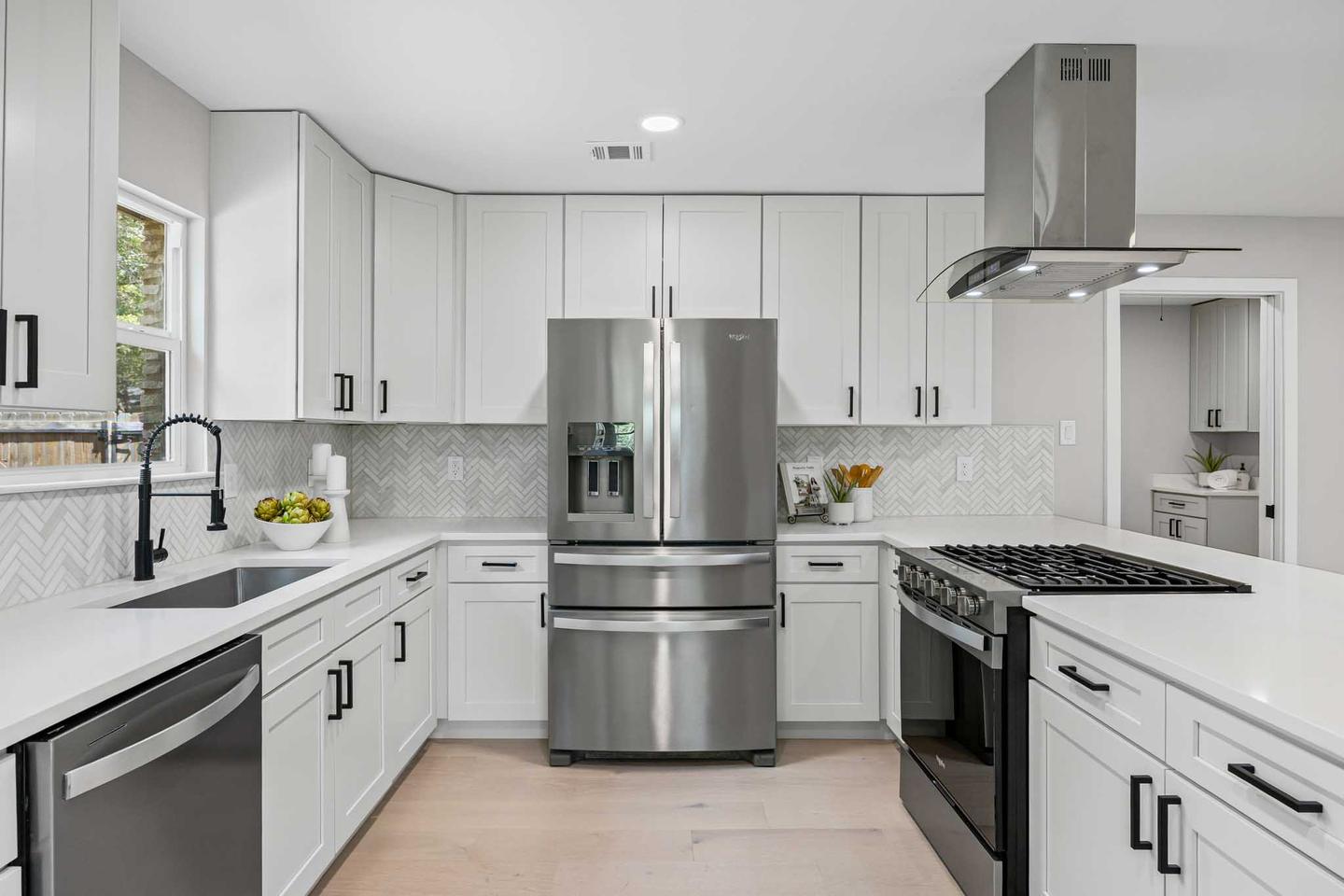 Bright white kitchen in Austin with stainless appliances and a large island