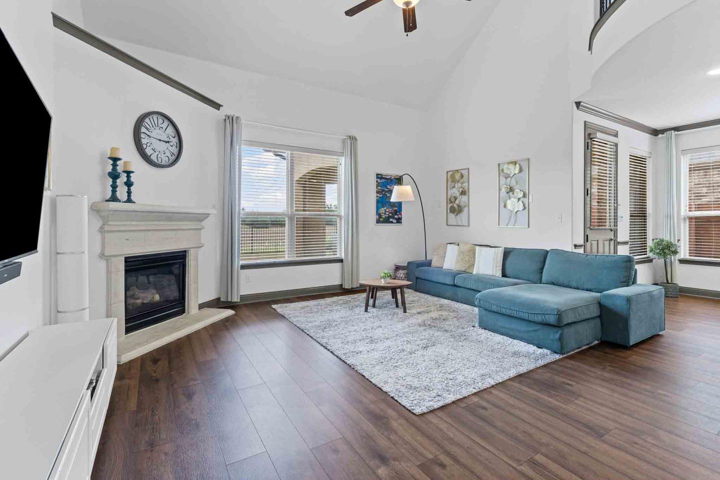 Living room in Leander with a blue sofa, a fireplace and a vaulted ceiling