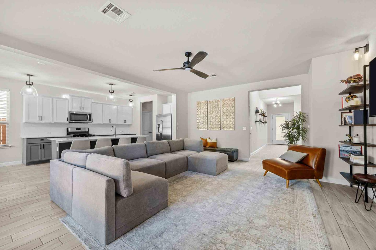 Open plan living room and kitchen in Austin with a gray sectional and wide windows