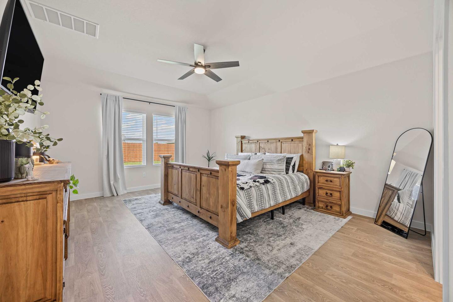 Primary bedroom in a Cedar Park home with a timber bed frame and a vaulted ceiling
