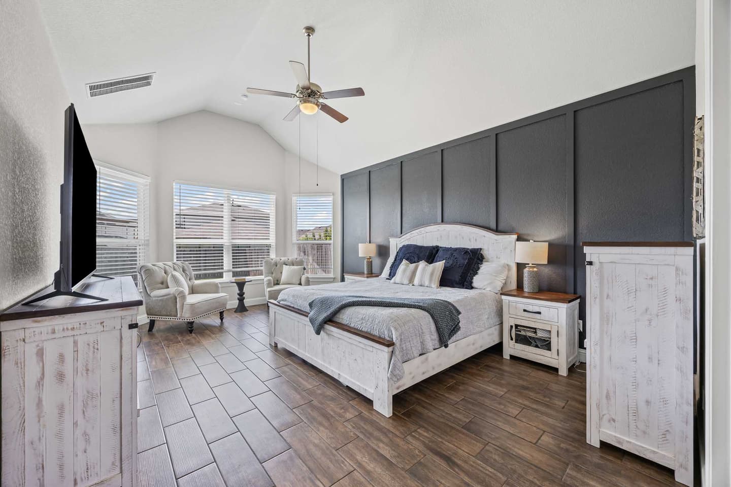 Primary bedroom in a Georgetown home with a tray ceiling and an upholstered headboard