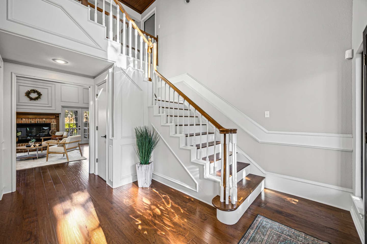 Curved staircase with white balusters and a wood handrail in a Westlake home entryway
