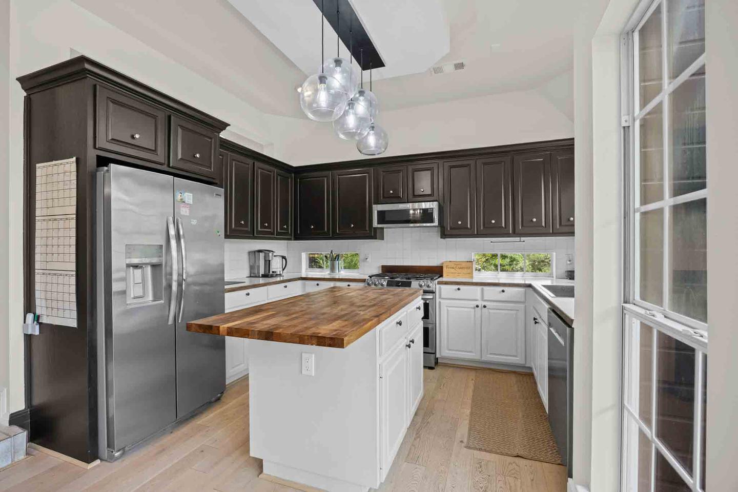 Two tone kitchen with an island, pendant lighting and unfurnished floors in a new Austin build