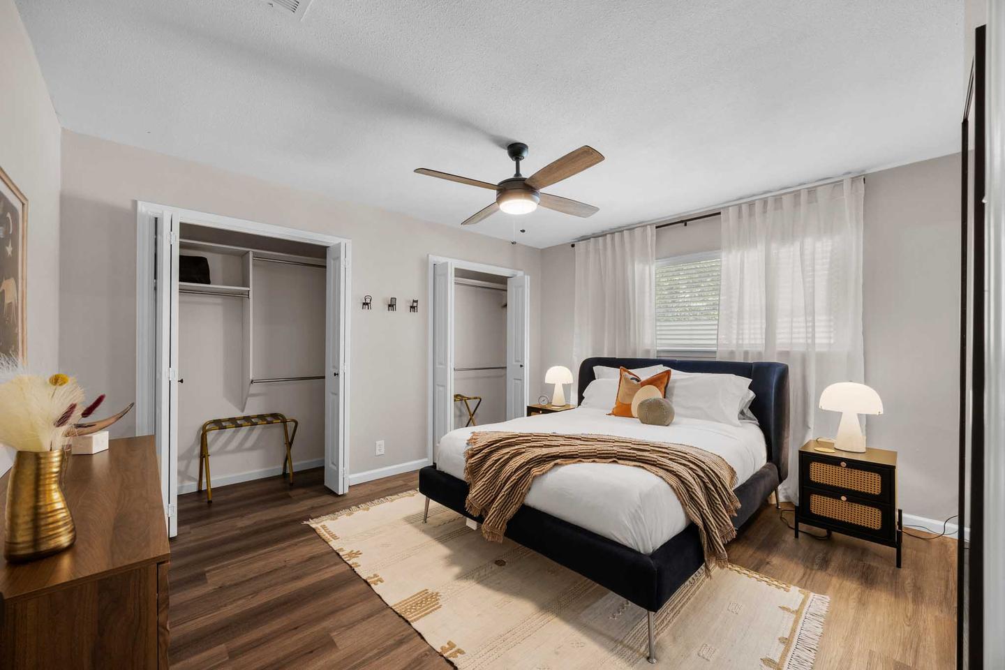 Bedroom in Cedar Park with a dark bed frame and a mirrored closet