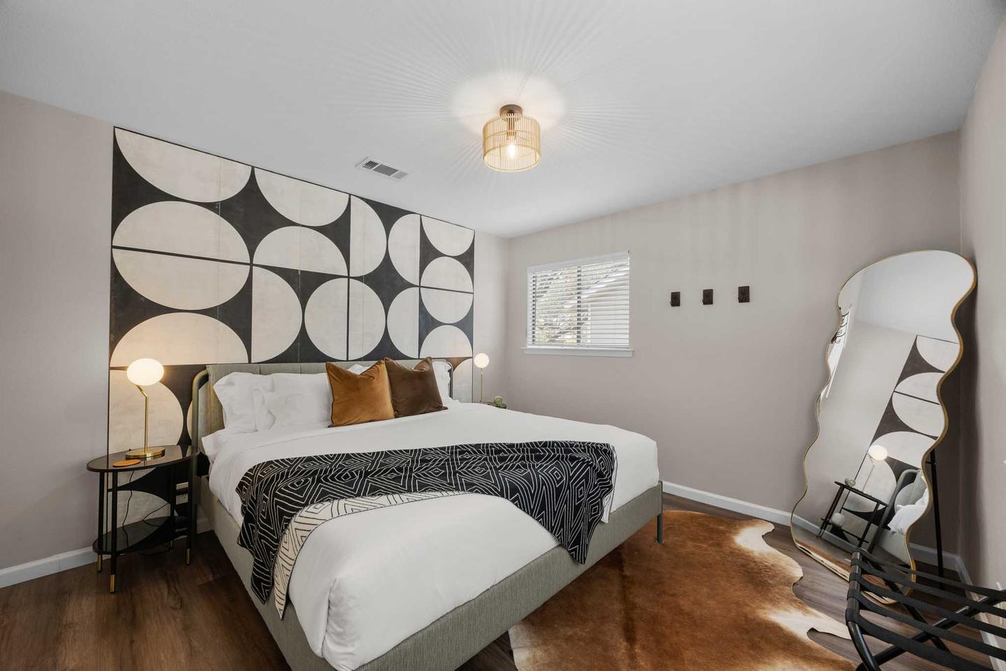 Short term rental bedroom in Round Rock with a graphic headboard wall and a bouclé armchair