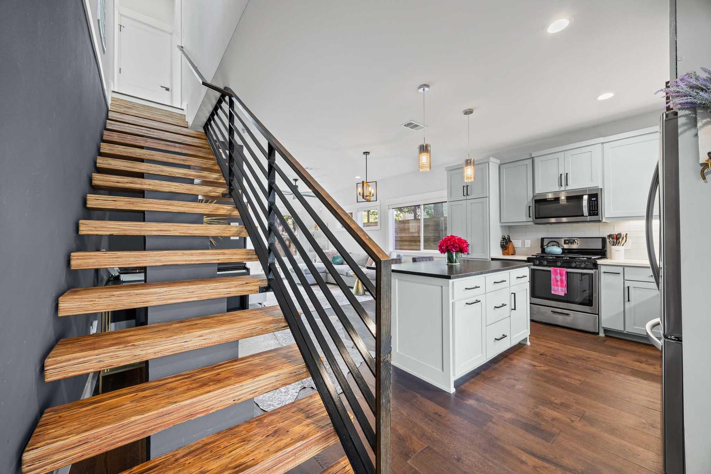Open tread timber staircase in a South Austin townhome against a dark accent wall