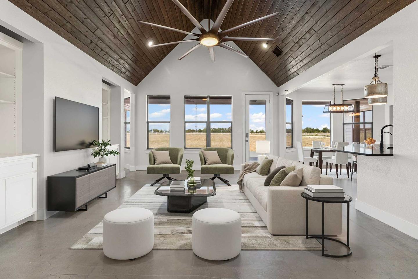 The same Cedar Park great room staged with pale seating, a long rug and a console