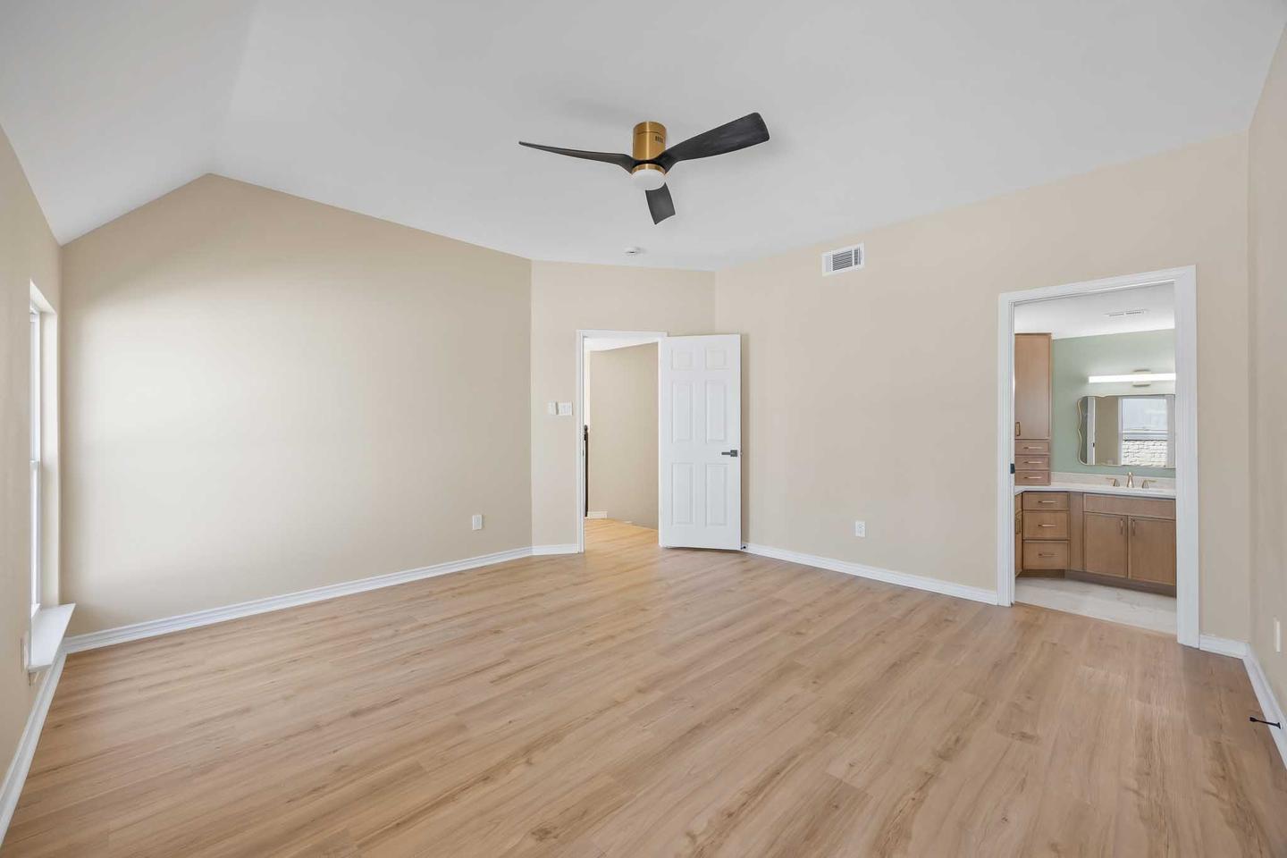 Empty bedroom in Georgetown with a vaulted ceiling, ceiling fan and light wood floor