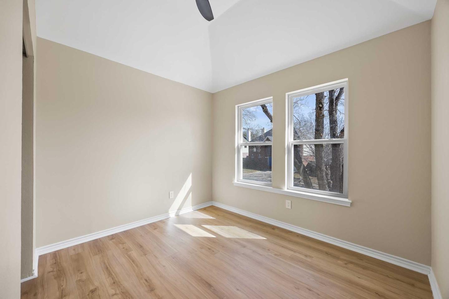 Empty spare room in Hutto with two windows and bare wood flooring