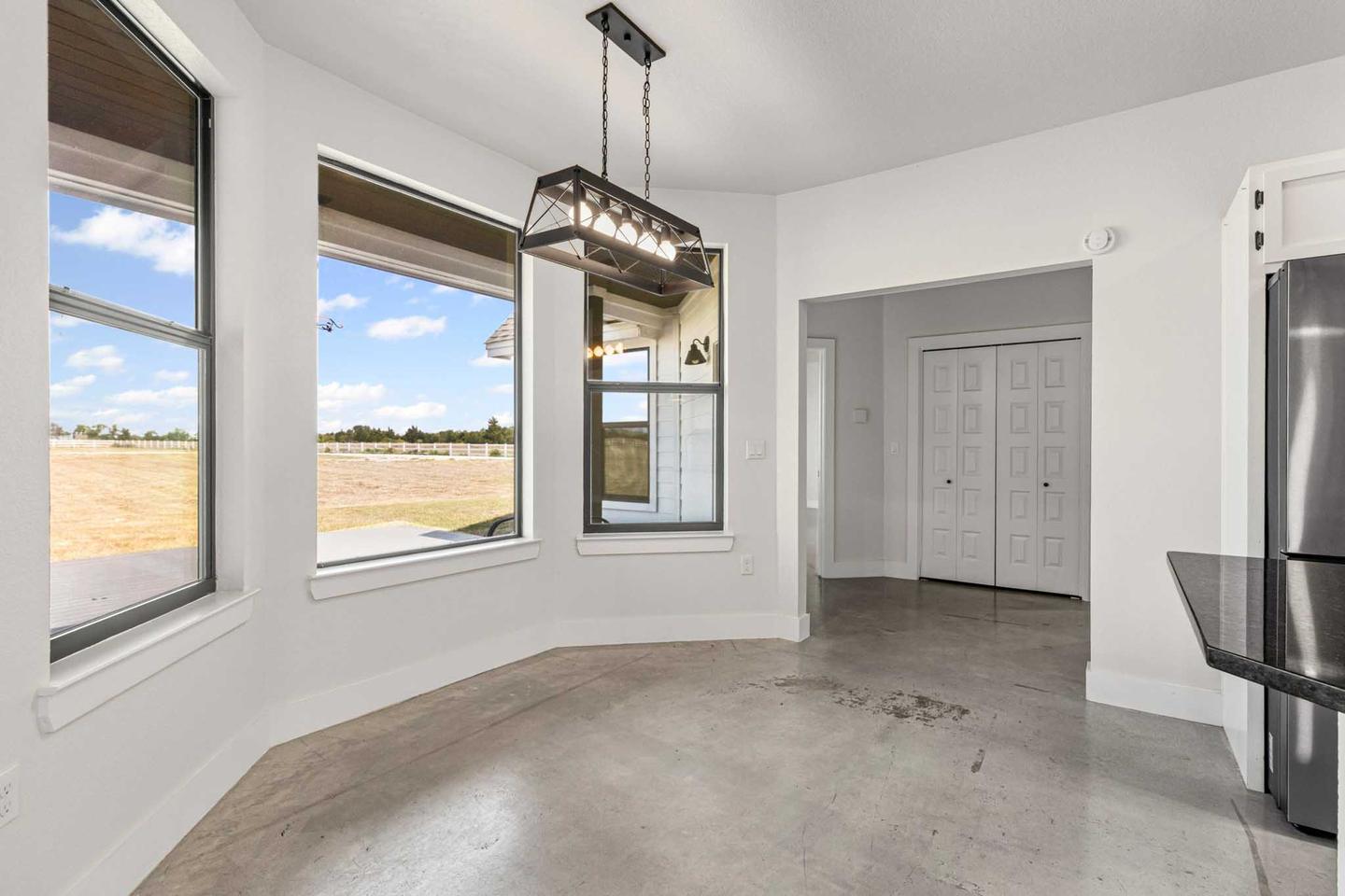 Empty dining area in a Manor home with a bay of windows and bare floor