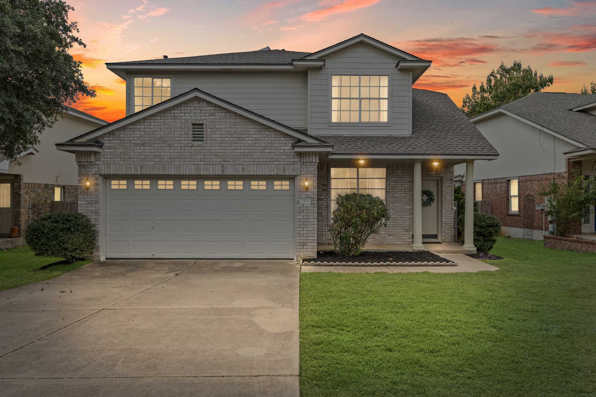 Round Rock home rendered at dusk with warm light in the windows and a colored sky